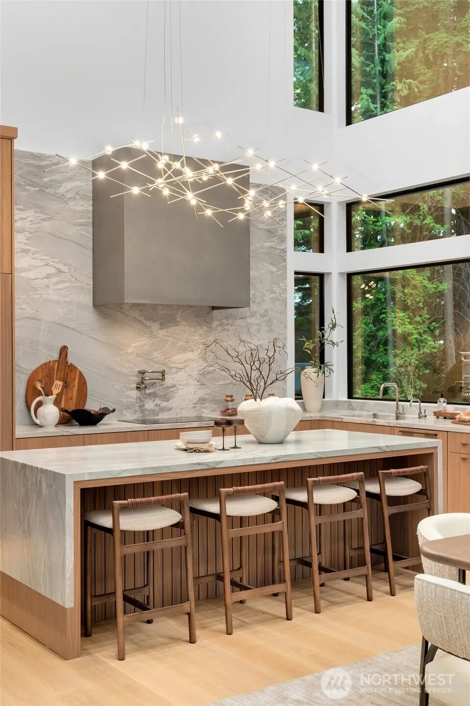 Custom plaster range hood, waterfall edge, pop up outlets, and an ultra lux Miele® appliance package.